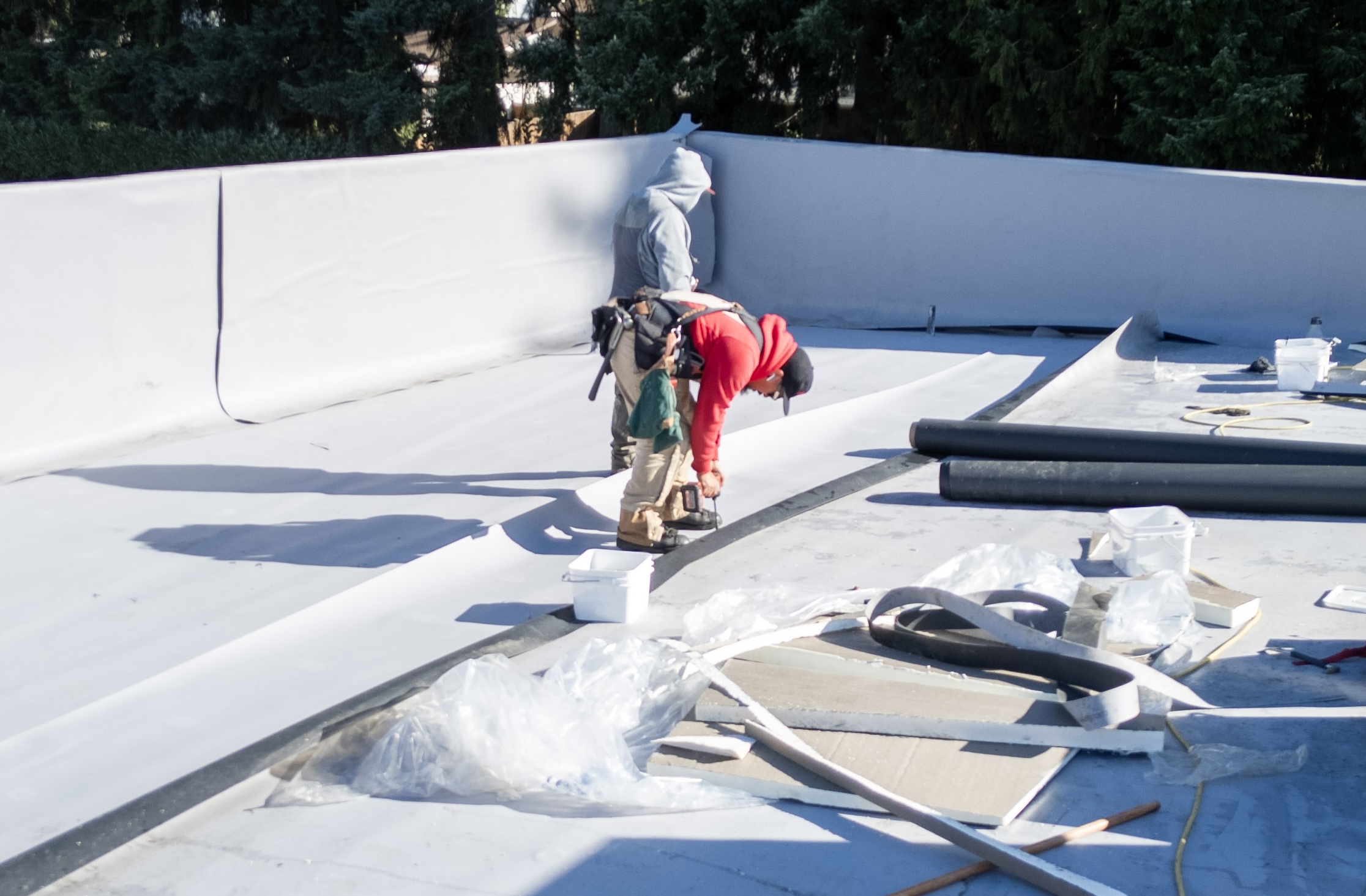 Workers repairing a flat roof.