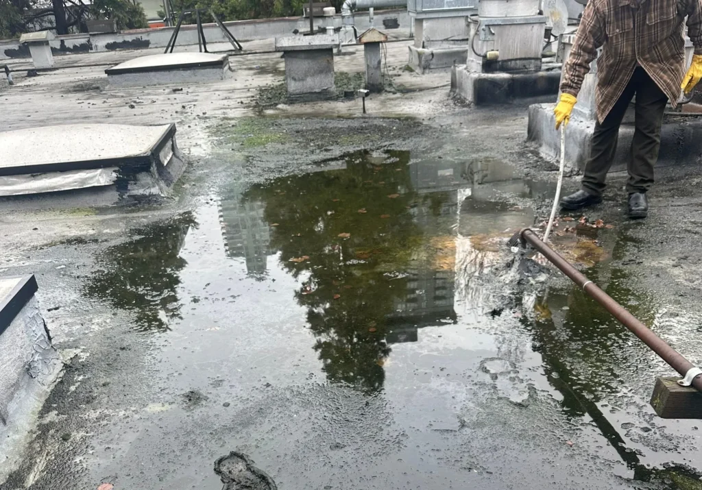 Man cleaning water from rooftop